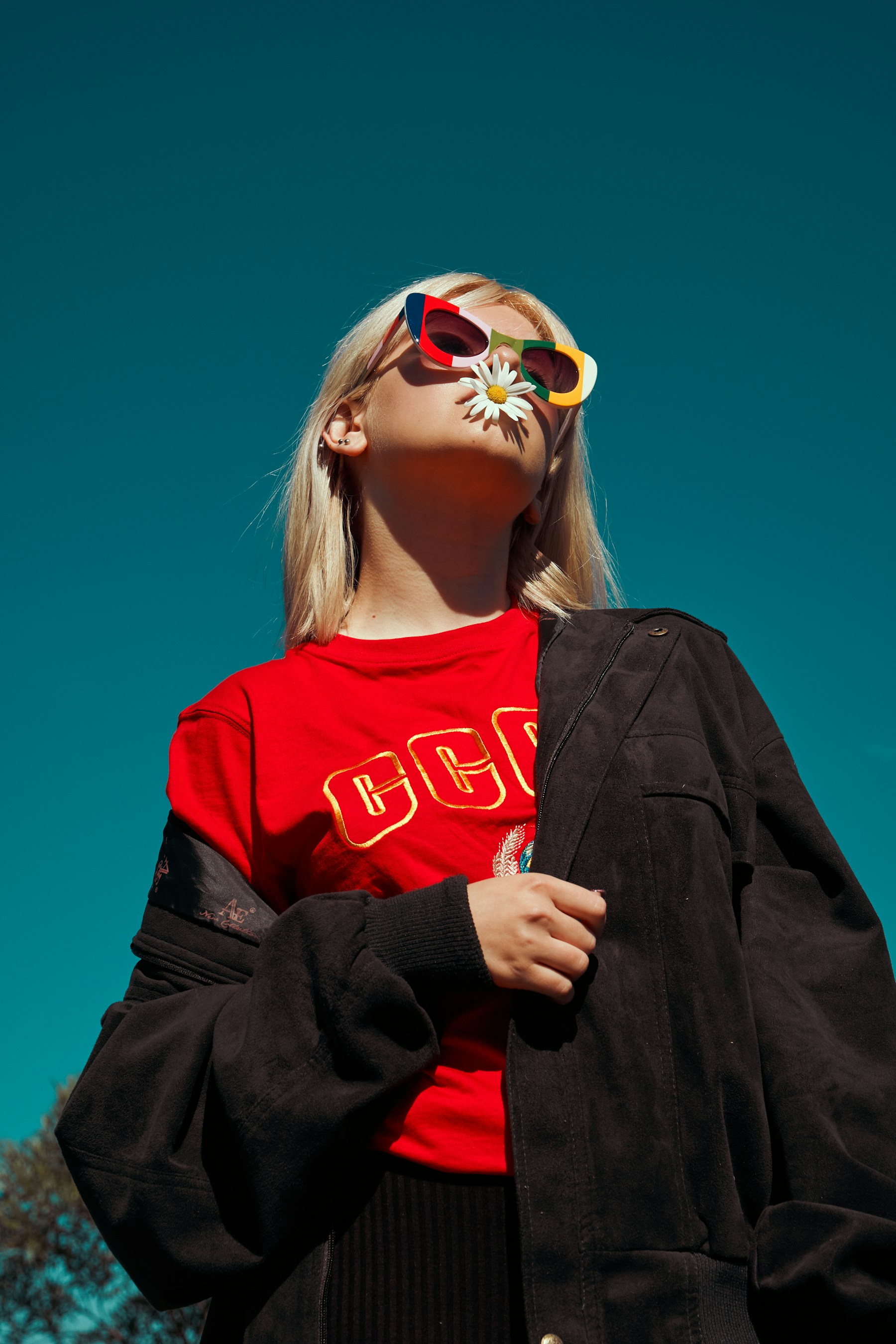 Bold editorial portrait against a vivid blue sky
