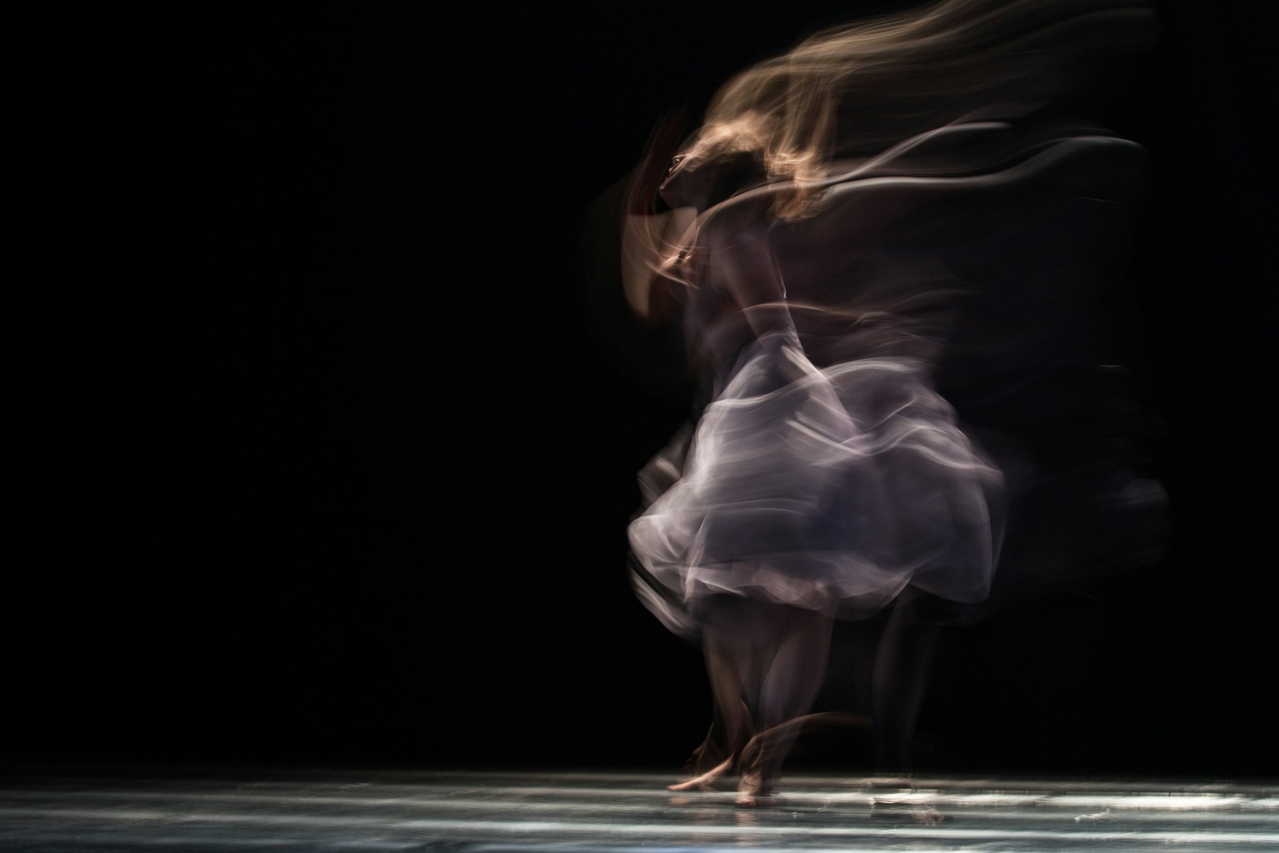 Ballet dancer holding a poised position in a bright studio